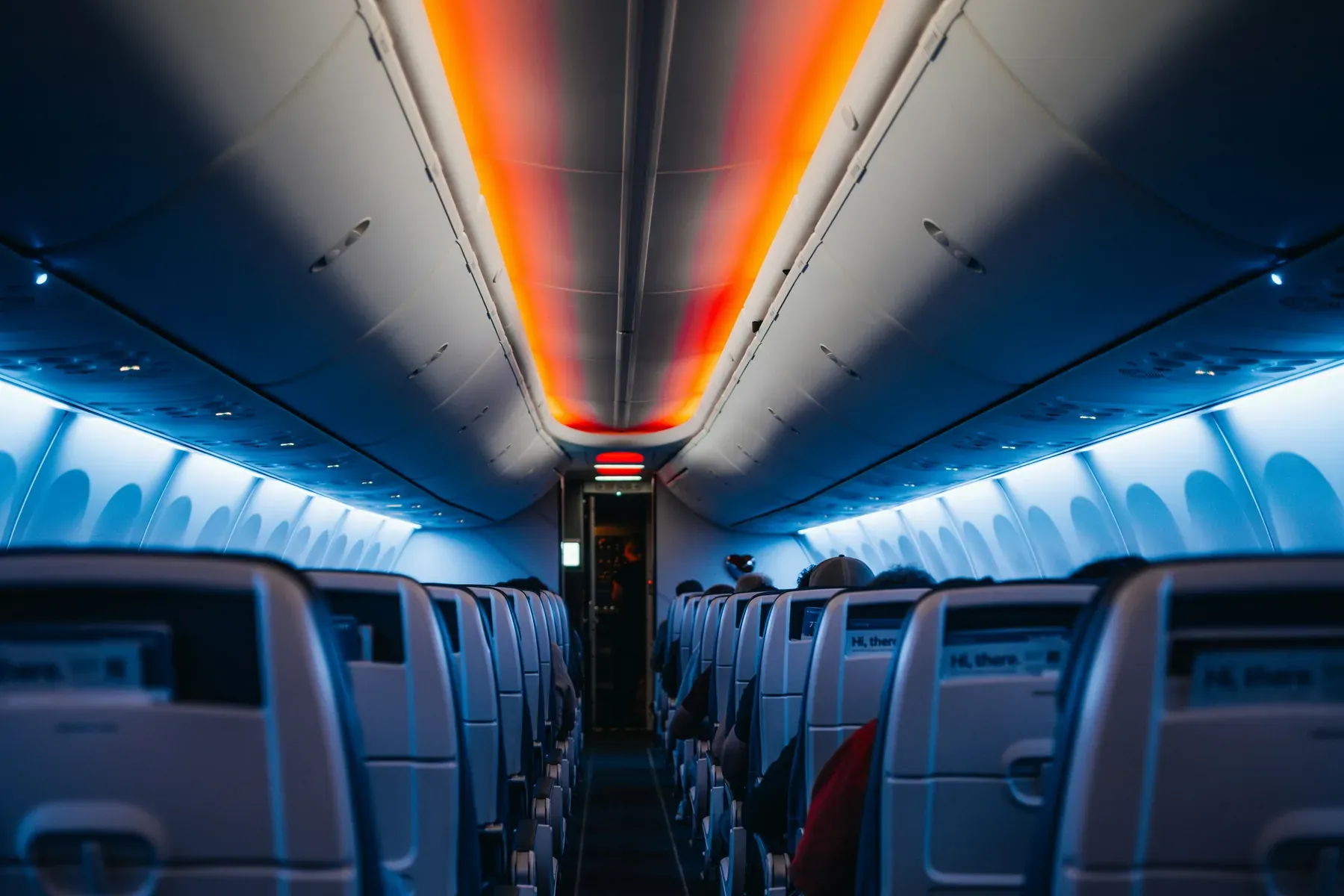 Aisle of an aircraft cabin with the overhead bins above the seats