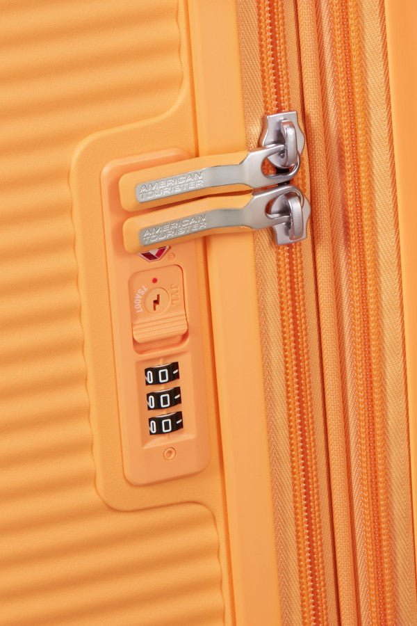 Kodlås med nyckelhål märkt TSA007 på en orange American Tourister Soundbox